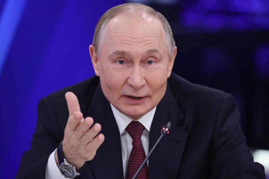 Russian President Vladimir Putin speaks into a microphone at the World Atomic Week forum.