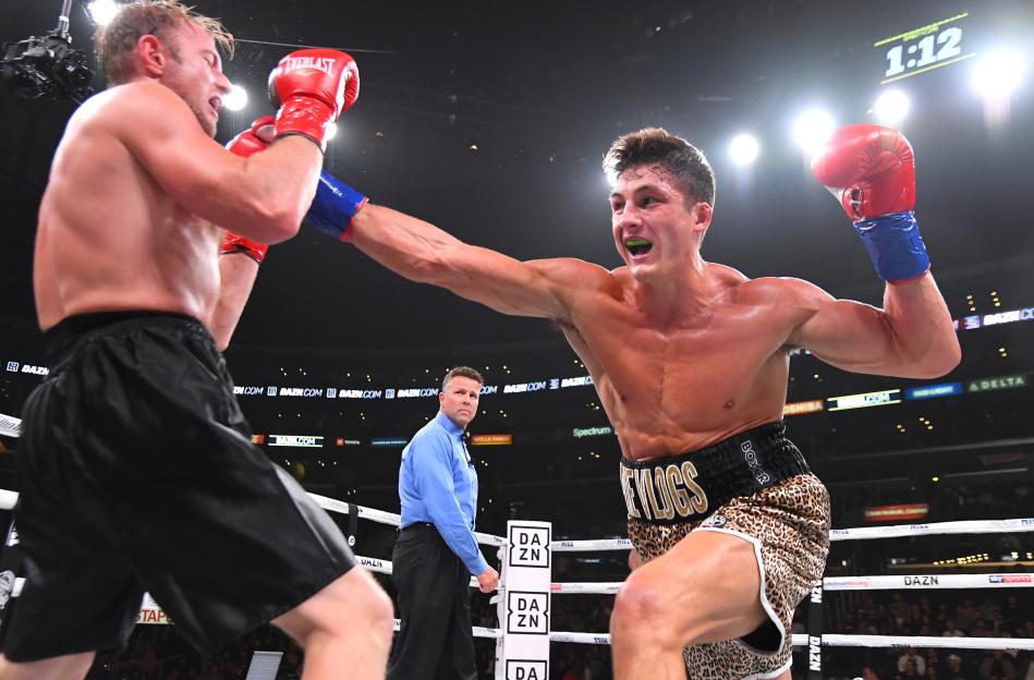 Josh Brueckner (wearing cheetah print shorts) lands a punch on Tyler Smith (wearing black shorts) during their pro debut boxing match.
