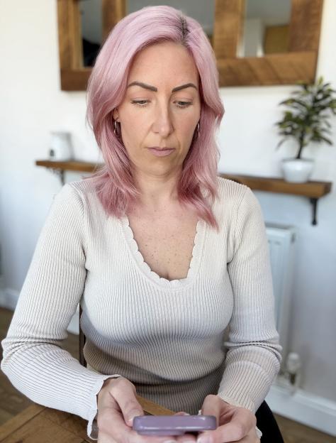 Samantha Bradshaw, a victim of a banking scam, looking at her phone.