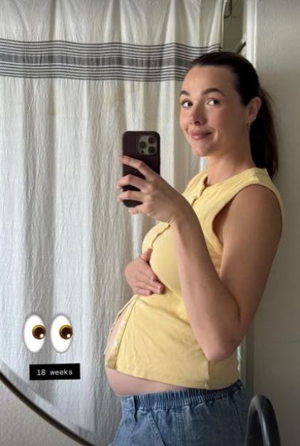 Pregnant Demi Harman showing her 18-week baby bump while taking a mirror selfie.