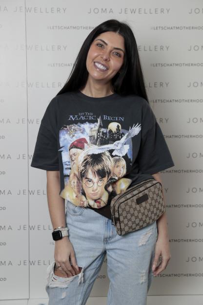 Cara Delahoyde-Massey wearing a Harry Potter t-shirt and light blue distressed jeans, a Gucci bag, and an Apple Watch.
