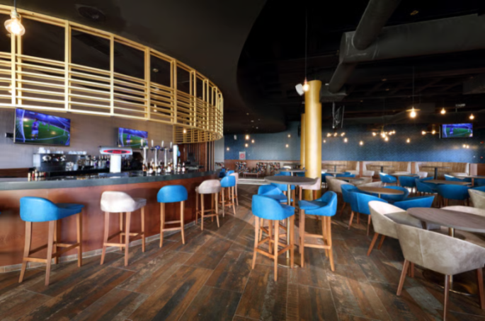 Interior of Hard Rock Hotel Tenerife bar with blue bar stools and lounge seating.