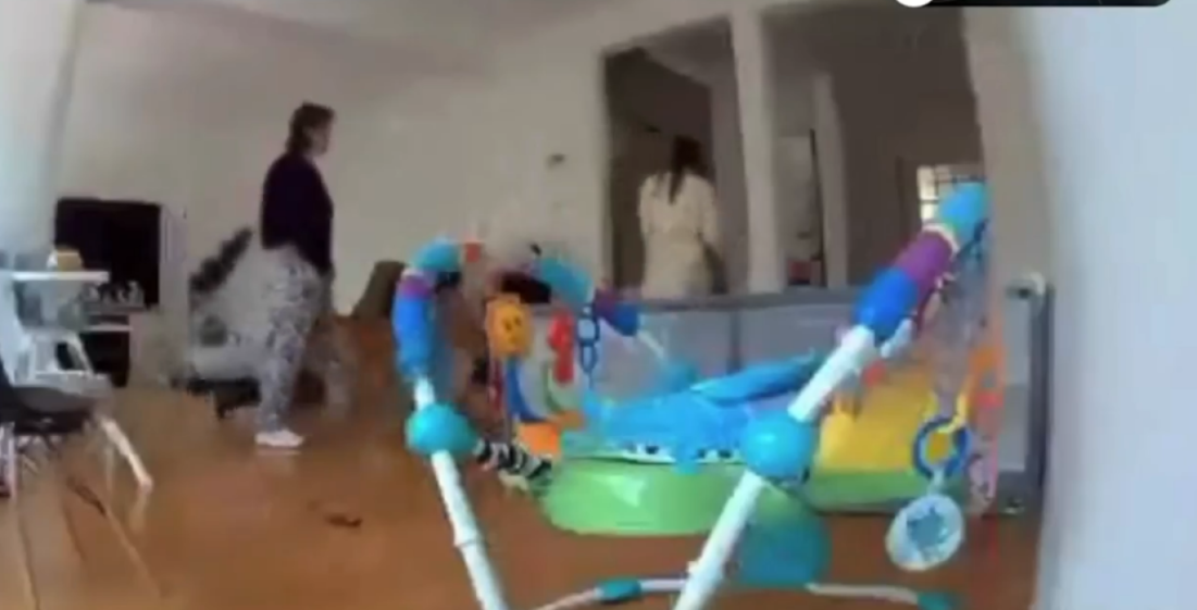 Surveillance footage showing a woman in patterned pants collapsing to the floor and another woman entering a doorway.