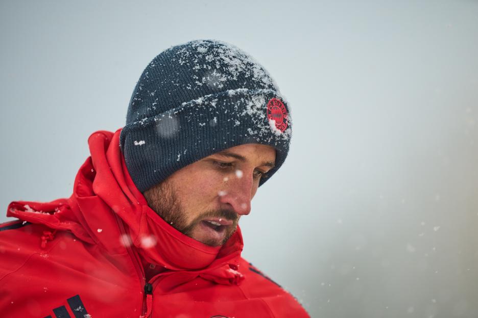 Harry Kane during a training session with snow on his beanie and jacket.