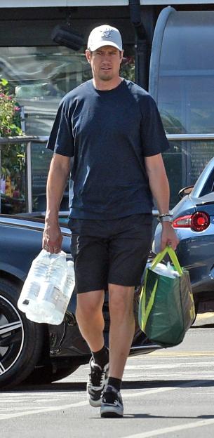 Vernon Kay carrying bottled water and a shopping bag after leaving a supermarket.