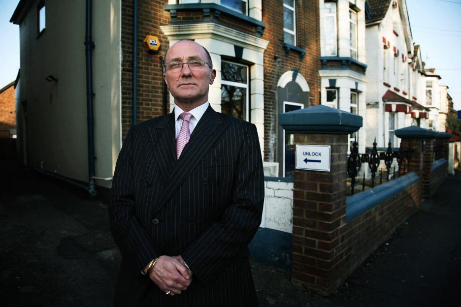 Bobby Cummines of the UNLOCK charity standing in front of residential buildings.