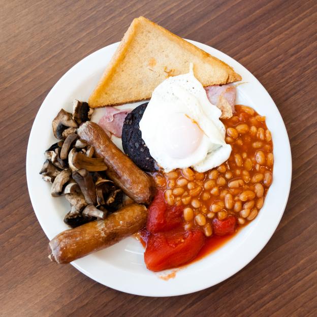 Full English breakfast, with black pudding fry up at a cafe. Fried breakfast overhead food UK.