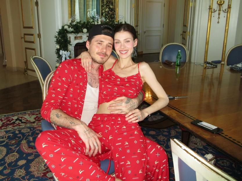 Brooklyn Beckham and Nicola Peltz in matching red Christmas pajamas.