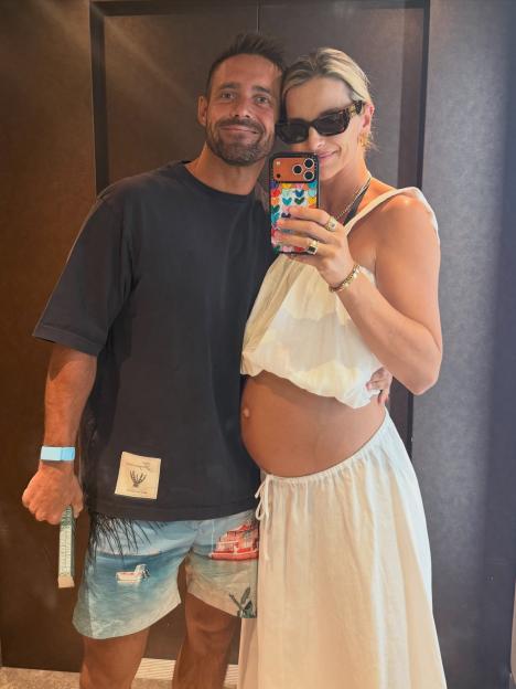 Vogue Williams taking a mirror selfie with her husband while showing her pregnant belly.