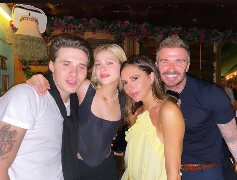 Brooklyn Beckham, Nicola Peltz, Victoria Beckham, and David Beckham smiling for a photo.