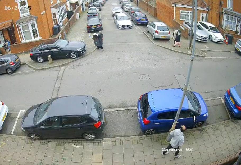 Overhead view of a residential street with parked cars, a pedestrian, and a mother with child crossing, seconds before a speeding vehicle crashed.