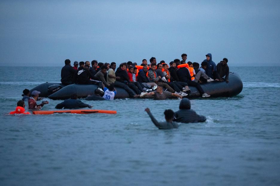 Migrants attempting a Channel crossing in a small, overcrowded boat.