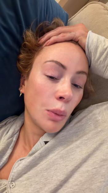 Olivia Attwood resting her head on a blue pillow, looking at the camera.