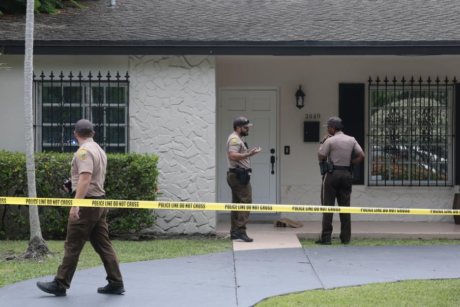Miami-Dade County Sheriff's deputies outside the residence of celebrity blogger Perez Hilton, cordoned off by "POLICE LINE DO NOT CROSS" tape.