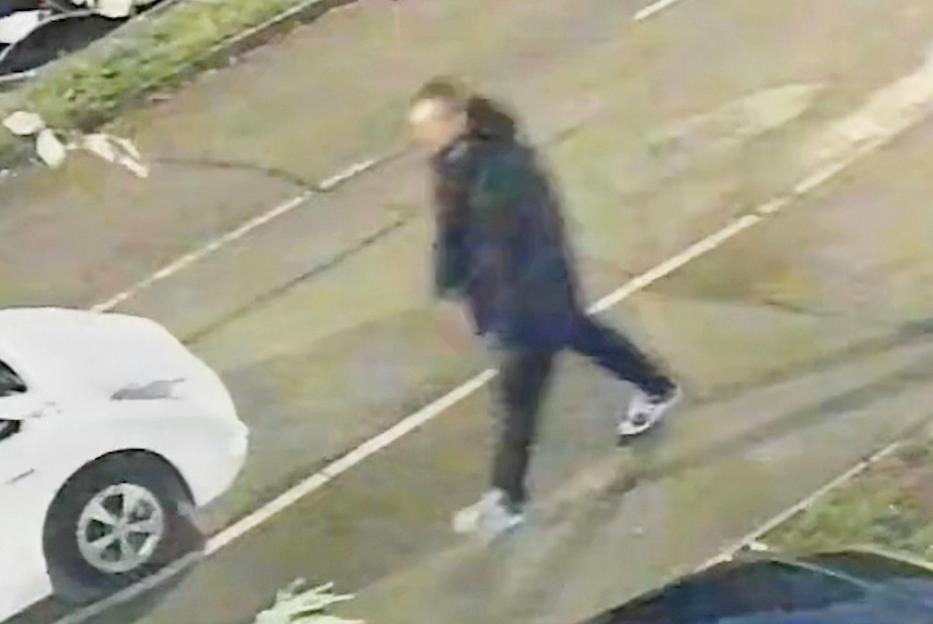 CCTV footage showing John Ashby walking down a street past a parked white car.