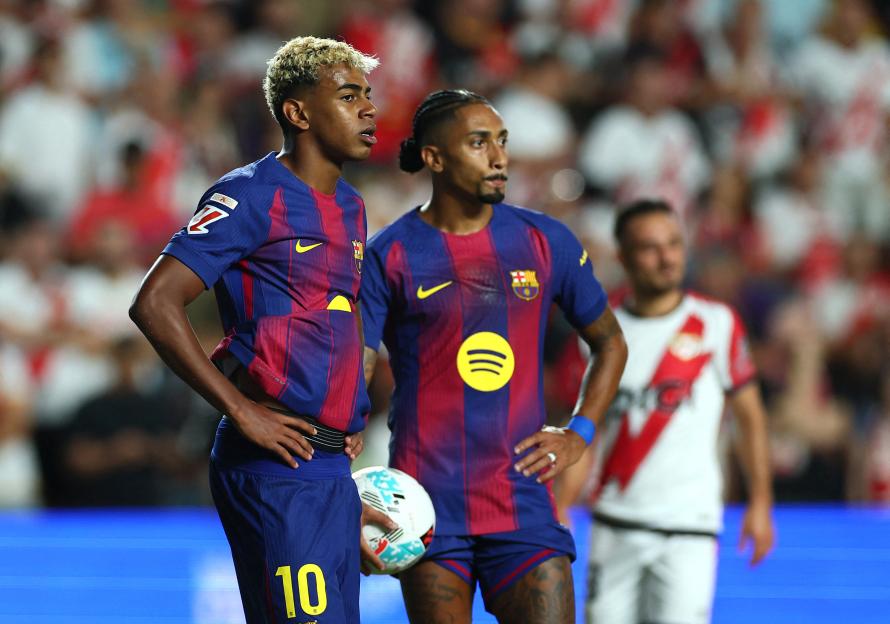 FC Barcelona's Lamine Yamal and Raphinha wait to take a penalty kick.