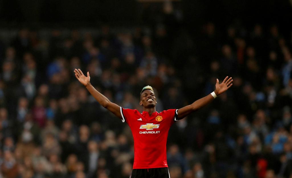 Manchester United midfielder Paul Pogba celebrates with arms outstretched.