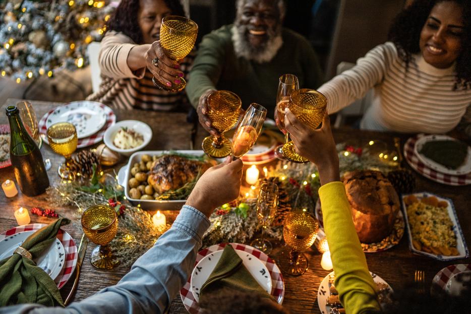 Family members toasting with drinks at a Christmas dinner table.