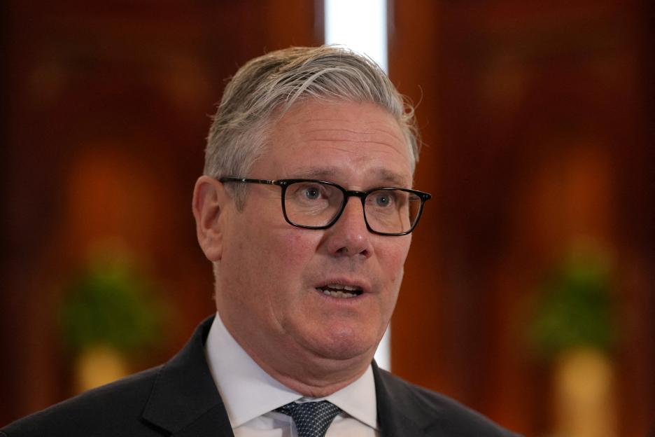 Britain's Prime Minister Keir Starmer speaks to the media at an airport.