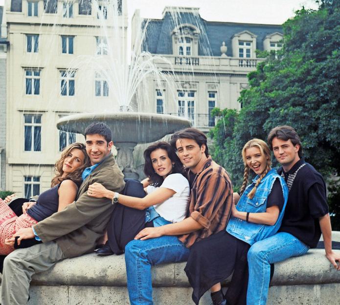 The six principal actors from Friends posing on a fountain.