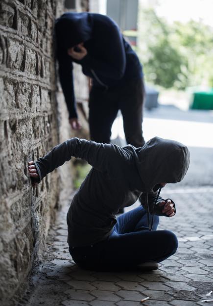a man in a hooded jacket is standing behind a woman in a hoodie