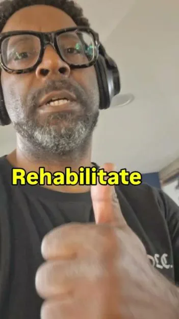 Kevin Mathurin giving a thumbs up with the word "Rehabilitate" on the screen.