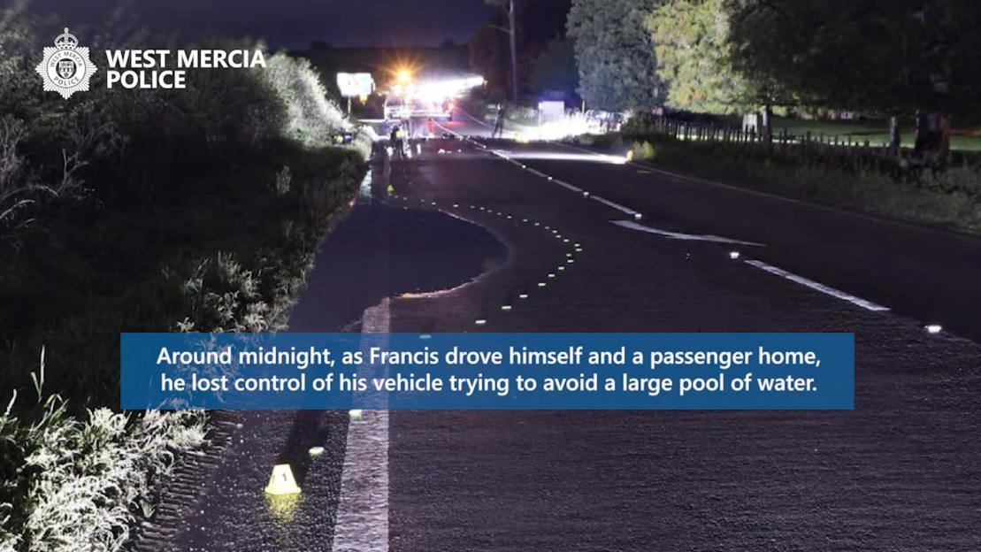 Nighttime image of a rural road with a large puddle and police vehicles in the distance, a blue text box overlayed reads: "Around midnight, as Francis drove himself and a passenger home, he lost control of his vehicle trying to avoid a large pool of water."