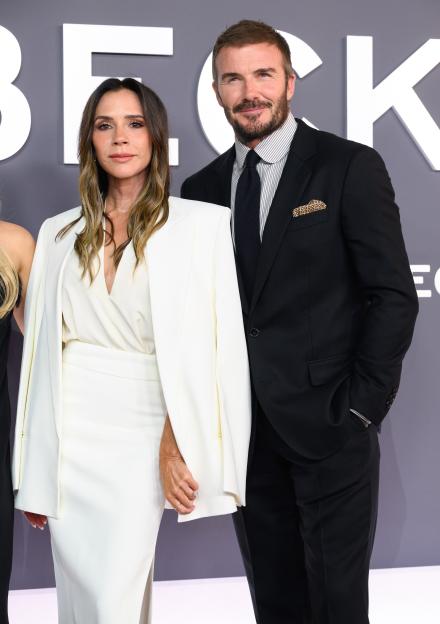 Victoria Beckham in a white dress and David Beckham in a black suit.