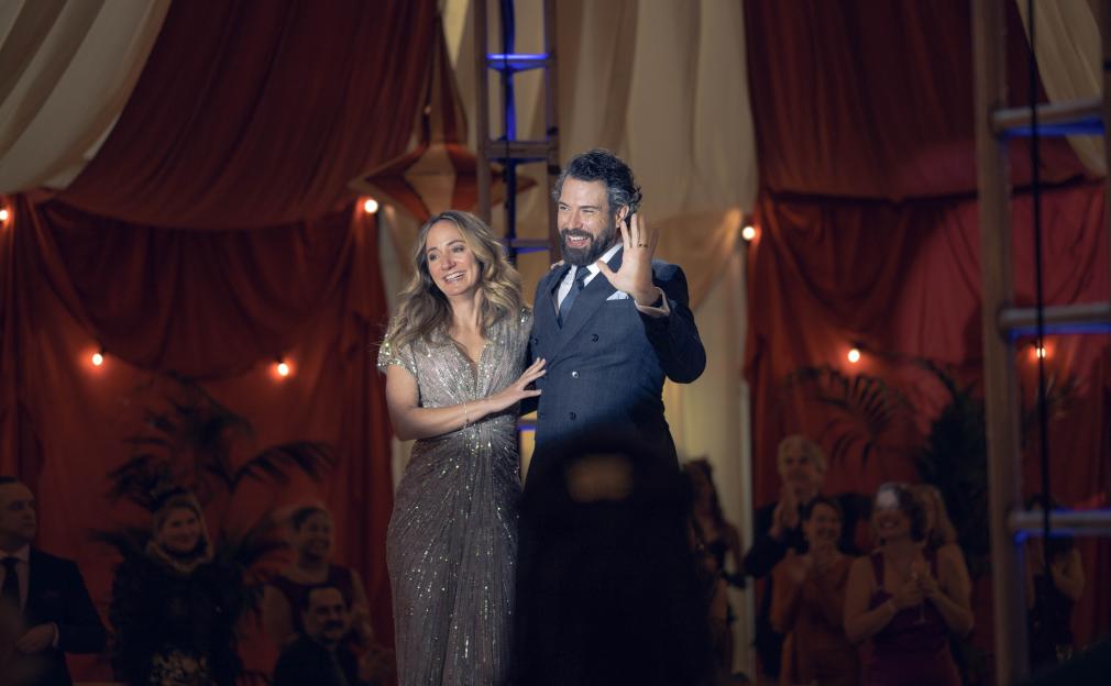 Lydia Leonard as Serena Fitzmaurice and Tom Cullen as Ben Fitzmaurice smiling and waving to a crowd at a party.