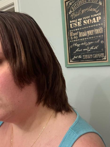 A woman's hair is poorly cut with uneven layers, showing a jagged line at her jawline.