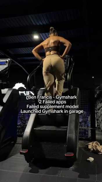 A woman from behind, working out on a stair climber at a gym, with overlaid text about Gymshark's founder.