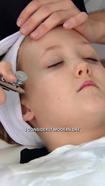 A young girl receiving a cosmetic treatment with a white headband on.