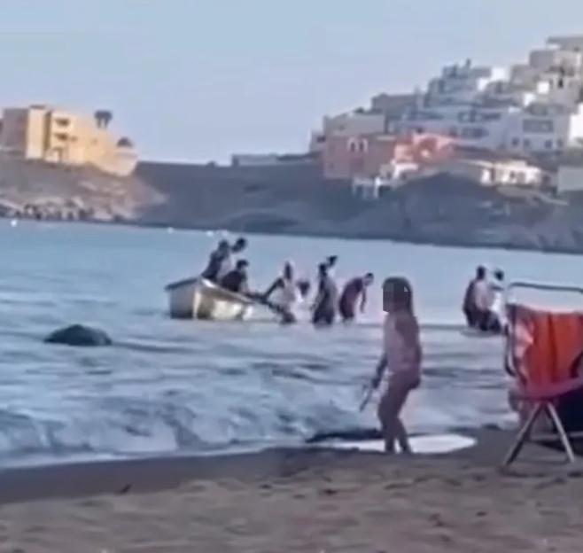 VIDEO: Migrant ¿taxi boat¿ arrives at popular beach before nine men jump off and wade ashore