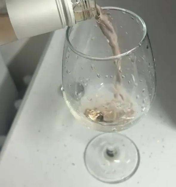 Wine being poured from a bottle into a glass, with the text "Alcohol-free wine from M&S" above it.
