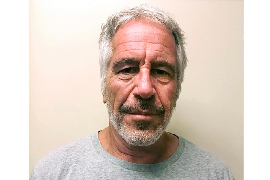 Mugshot of Jeffrey Epstein with short gray hair, a gray beard and mustache, and wearing a gray t-shirt.