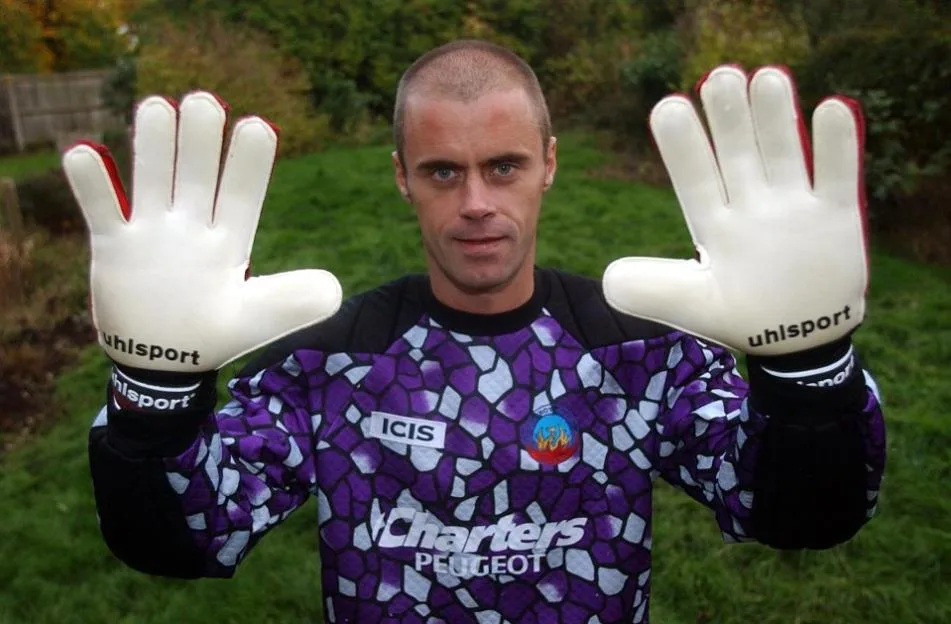 Aldershot goalkeeper Gareth Howells holding up his hands in goalie gloves.
