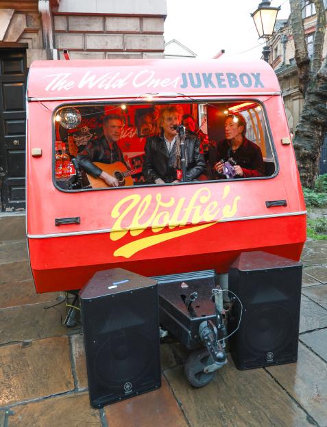 Sir Rod Stewart performing in a red caravan for his whisky brand, Wolfie's.