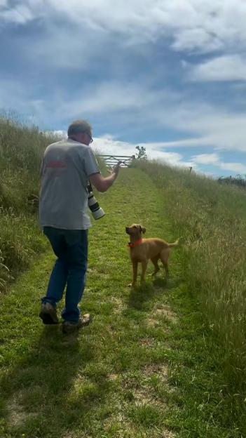 Jeremy Clarkson and his dog on a grassy path.