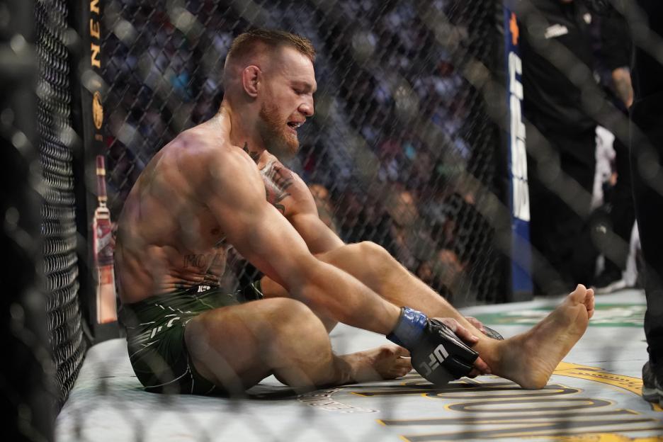 Conor McGregor holding his left ankle during a UFC lightweight bout.