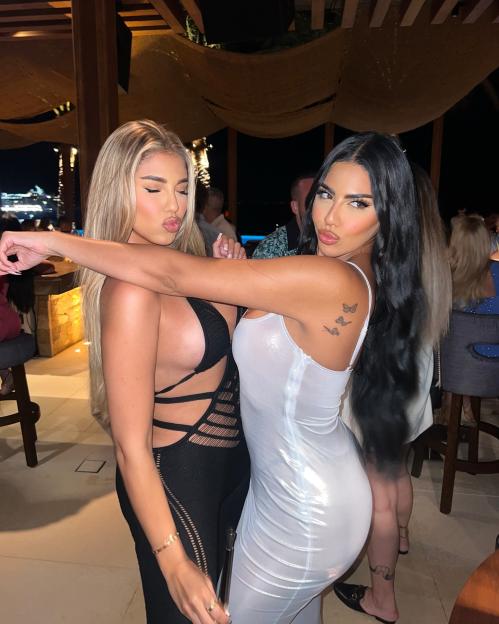 Mani Vakili, with blonde hair, kissing the cheek of another woman with dark hair.