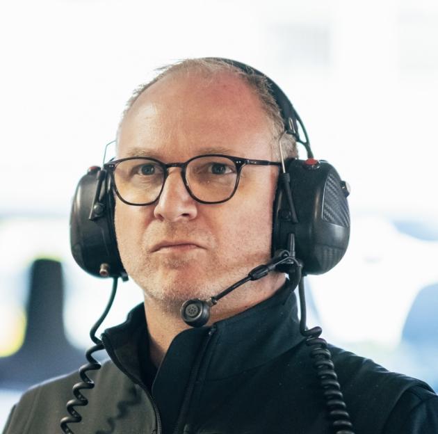 A man with glasses and a headset with a microphone.