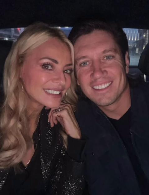Tess Daly and Vernon Kay smiling in a car.