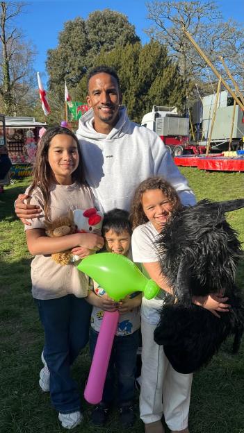 Scott Sinclair with his three children, two girls and one boy, holding prizes.