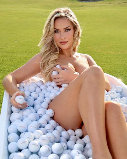 Paige Spiranac in a tub filled with golf balls.