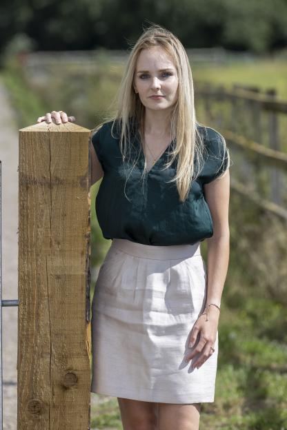 Lissie Harper, wife of murdered PC Andrew Harper, standing outside with her hand on a wooden post.