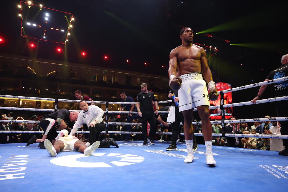 a man in a boxing ring with anthony joshua on his shorts