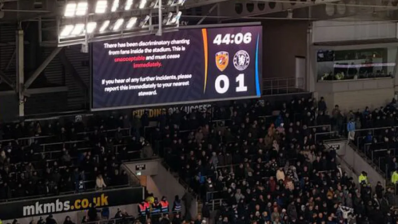 Scoreboard displaying a message about discriminatory chanting from fans during a Hull City vs. Chelsea football match, with Chelsea leading 1-0.