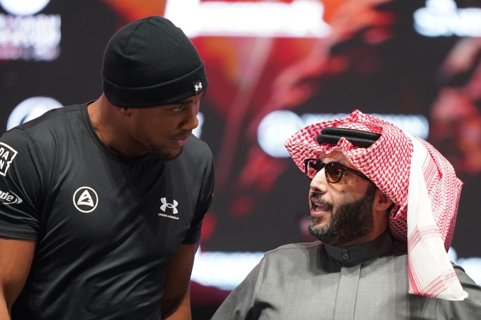 Anthony Joshua looking at Turki Al-Sheikh during a press conference.