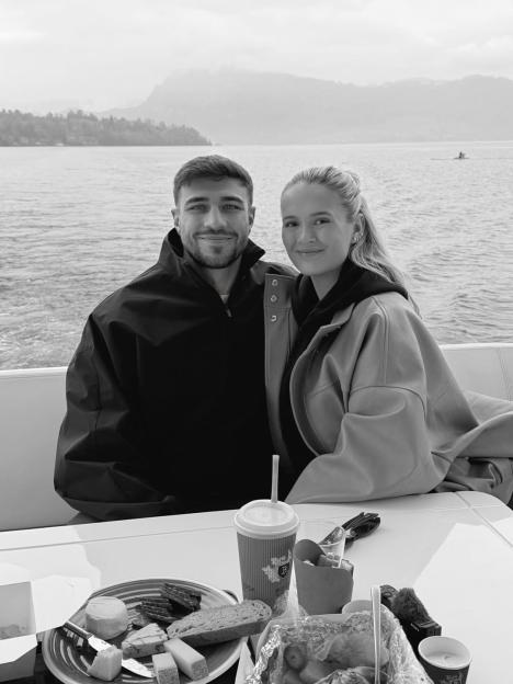 Molly-Mae Hague and Tommy Fury on a boat with food on a table in front of them.