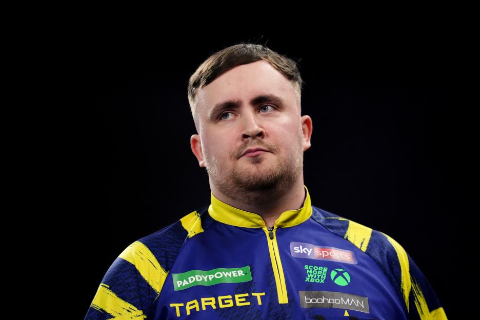 Luke Littler wearing a blue and yellow sports shirt.